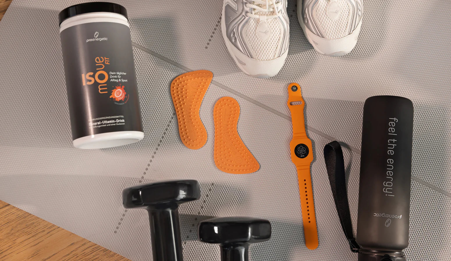 Verschiedene Vita & Active Produkte als Flatlay auf hellem Untergrund, darunter Trinkflasche, Armband, Einlegesohlen und Zubehör