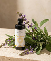 Aroma Diffuser Essence Awareness in dunkler Glasflasche mit Etikett, platziert neben frischem echtem Salbei mit violetten Blüten