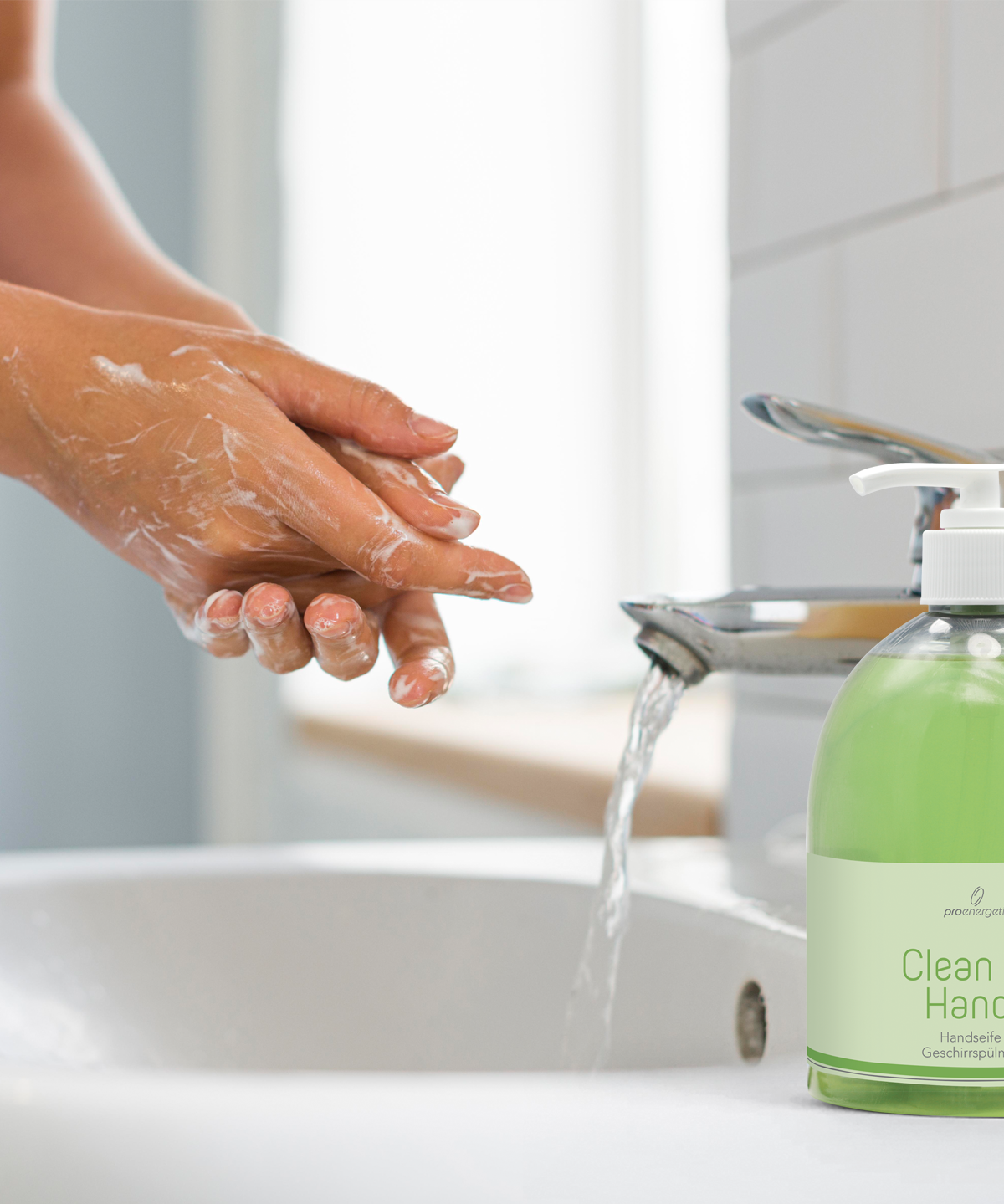 Hände werden an einem Waschbecken mit Clean my Hands Seife gewaschen, die grüne Pumpflasche steht neben dem Wasserhahn