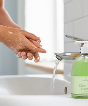 Hände werden an einem Waschbecken mit Clean my Hands Seife gewaschen, die grüne Pumpflasche steht neben dem Wasserhahn