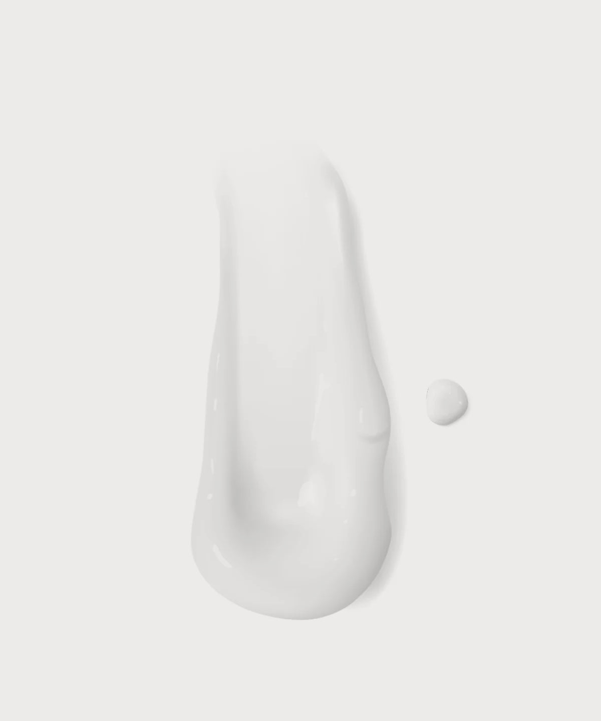 Weiße, cremige Textur des „Clean Skin“ Cleansers als Produkt-Swatch auf hellem Hintergrund, mit kleinem Tropfen daneben.