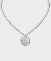 Silberfarbene E-Protect Necklace Halskette von ProEnergetic mit rundem Anhänger und blauem Punkt auf hellem Hintergrund.