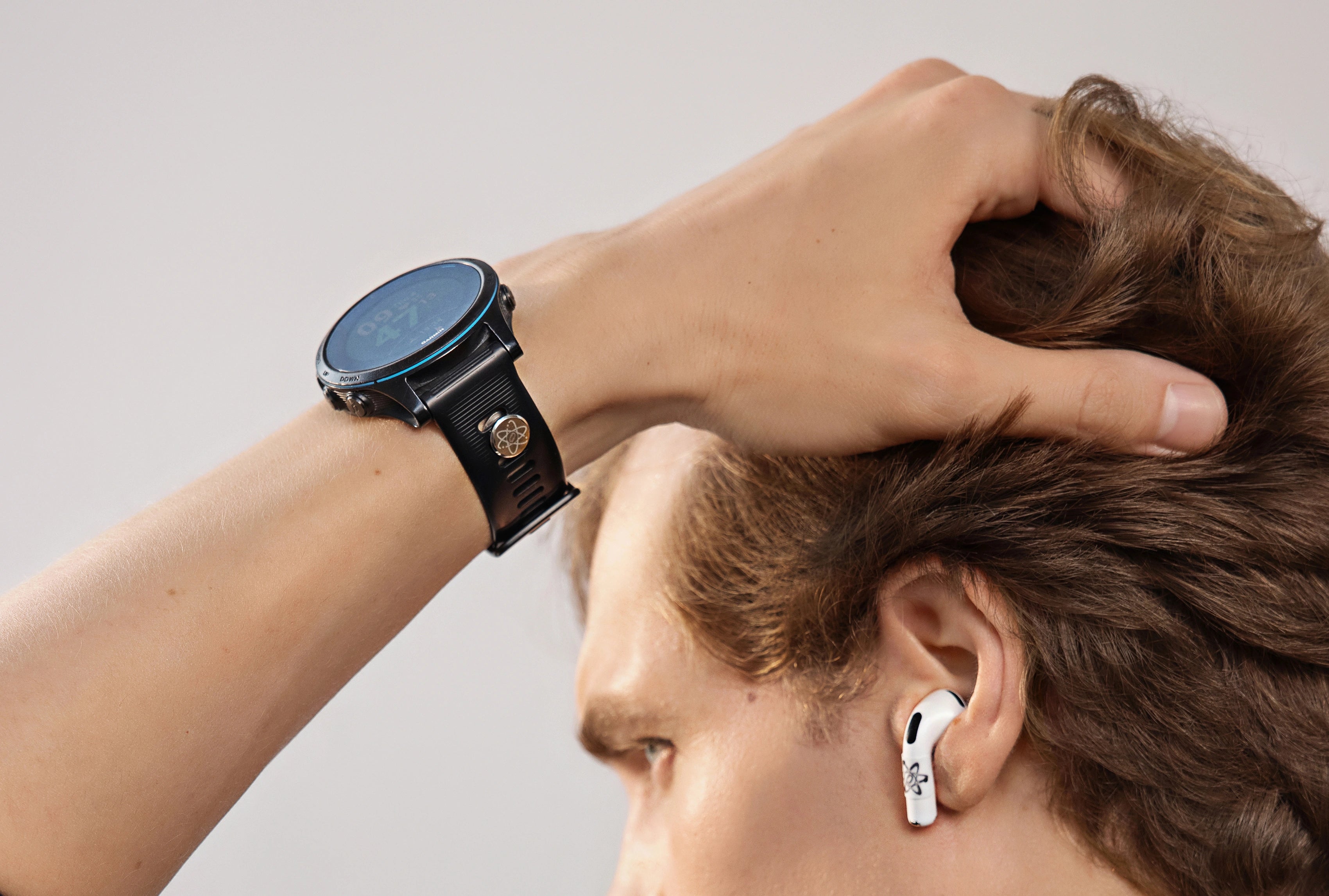 Mann im Innenraum mit seitlicher Ansicht trägt eine schwarze Smartwatch mit angebrachtem E-Protect Element am Handgelenk