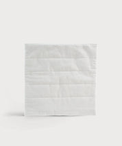 Quadratisches Grounding Relax Pad in weißer Textiloptik mit horizontalen Steppnähten auf neutralem Hintergrund