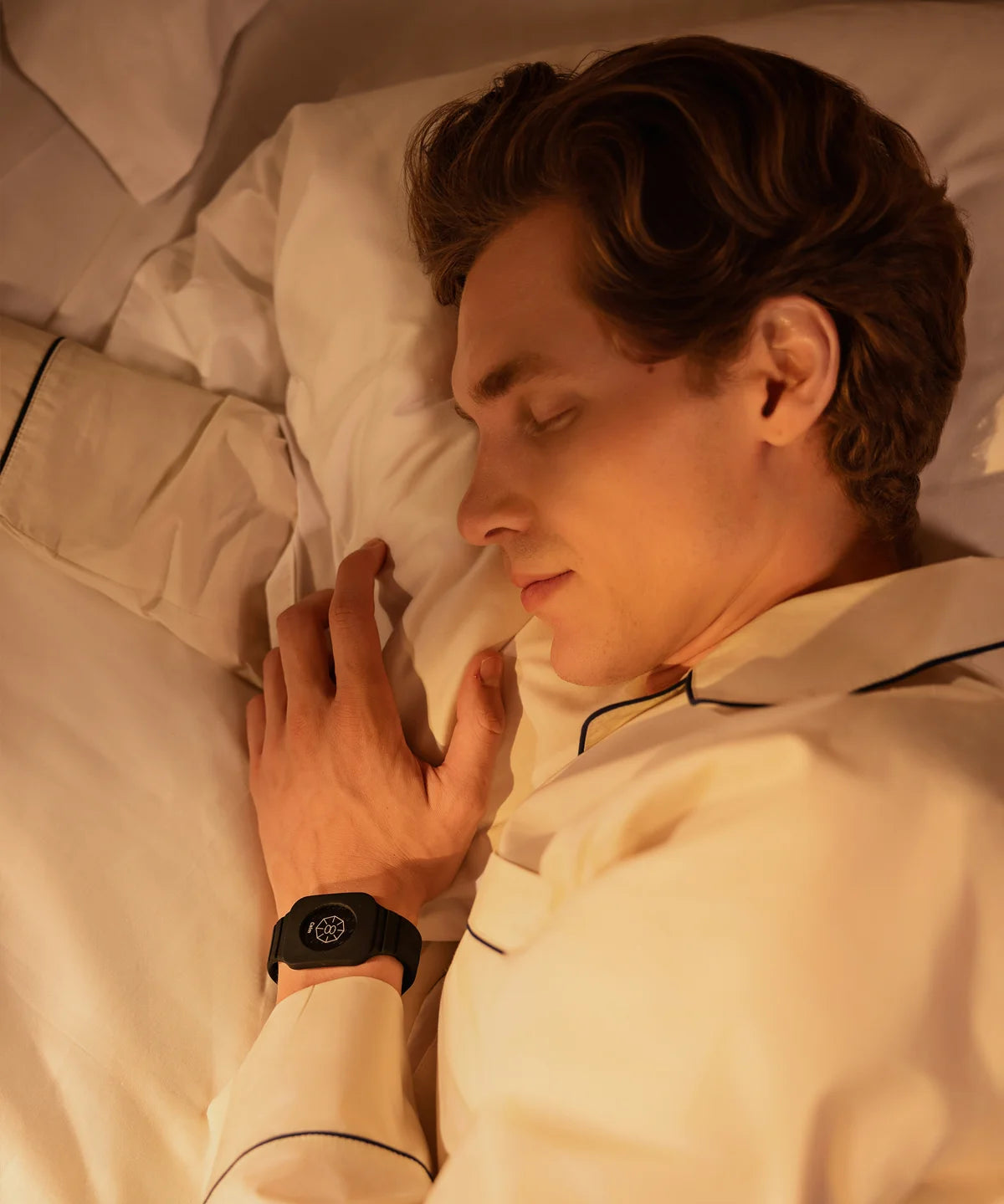 Person liegt im Bett auf der Seite und schläft auf einer Grounding Sleep Mat, die unter dem Bettlaken positioniert ist