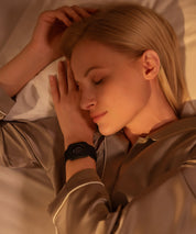 Person liegt im Bett auf der Seite und schläft ruhig auf einer Grounding Sleep Mat, die unter dem Bettlaken positioniert ist