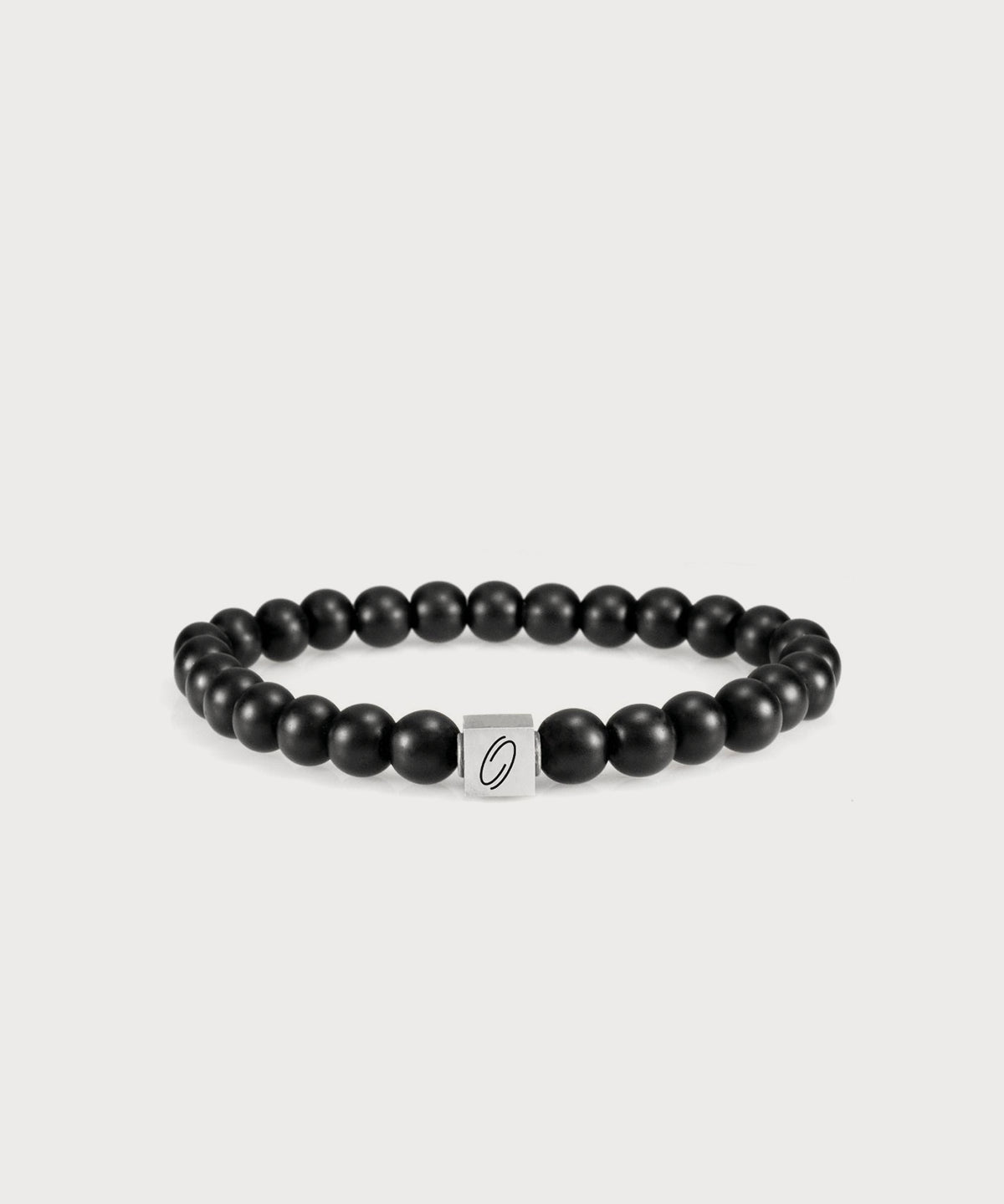 Schwarzes I AM Energy Armband mit matten Perlen und silberfarbenem Logoelement auf hellem Hintergrund