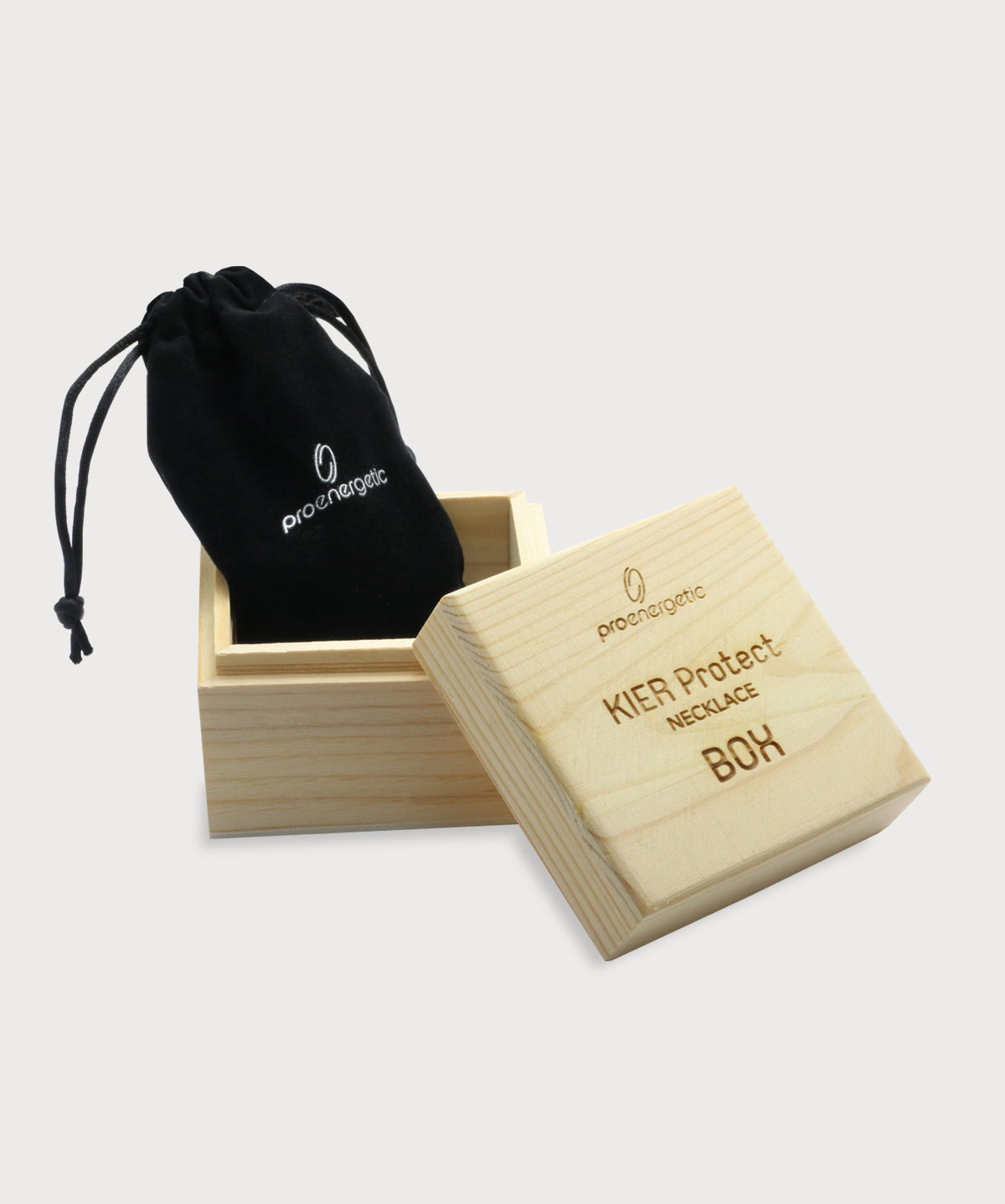 Holzbox mit geöffnetem Deckel und gravierter Beschriftung KIER Protect Necklace BOX, darin schwarzer ProEnergetic Stoffbeutel mit enthaltenem KIER Protect Necklace sichtbar