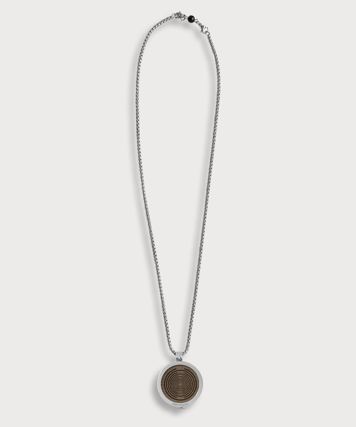 ProEnergetic KIER Protect Necklace mit silberfarbener Kette und rundem Anhänger aus Metall mit sichtbarer Holzscheibe und konzentrischem Linienmuster
