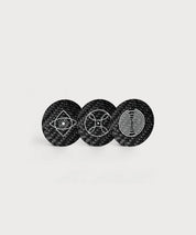 Drei runde schwarze Love & Light Chips von ProEnergetic mit Carbonstruktur und unterschiedlichen geometrischen Symbolen in Weiß auf hellem Hintergrund.