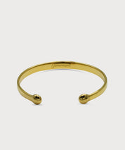 Goldfarbener Lunara Cuff Armreif mit polierter Oberfläche, offenen Enden und eingraviertem ProEnergetic Logo innen vor hellem Hintergrund