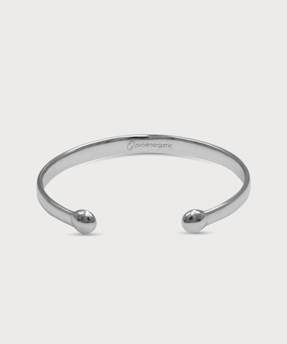 Silberner Lunara Cuff Armreif mit polierter Oberfläche, offenen Enden und eingraviertem ProEnergetic Logo auf der Innenseite vor hellem Hintergrund