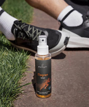 Das ProEnergetic Magnex Spray steht neben Laufschuhen auf einem Parkweg und verdeutlicht damit seine Verwendung vor oder nach dem Sport.