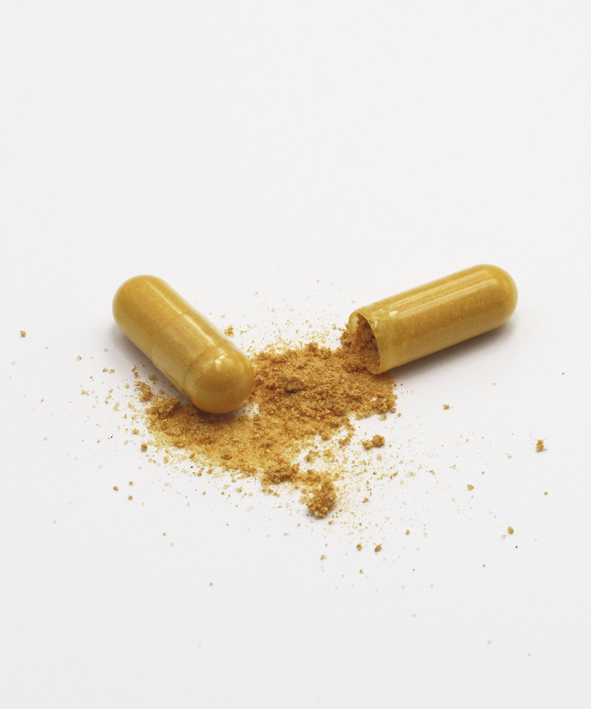 Eine geöffnete Motion Caps Kapsel mit gelblich braunem Pulver und eine geschlossene Kapsel auf hellem Hintergrund.