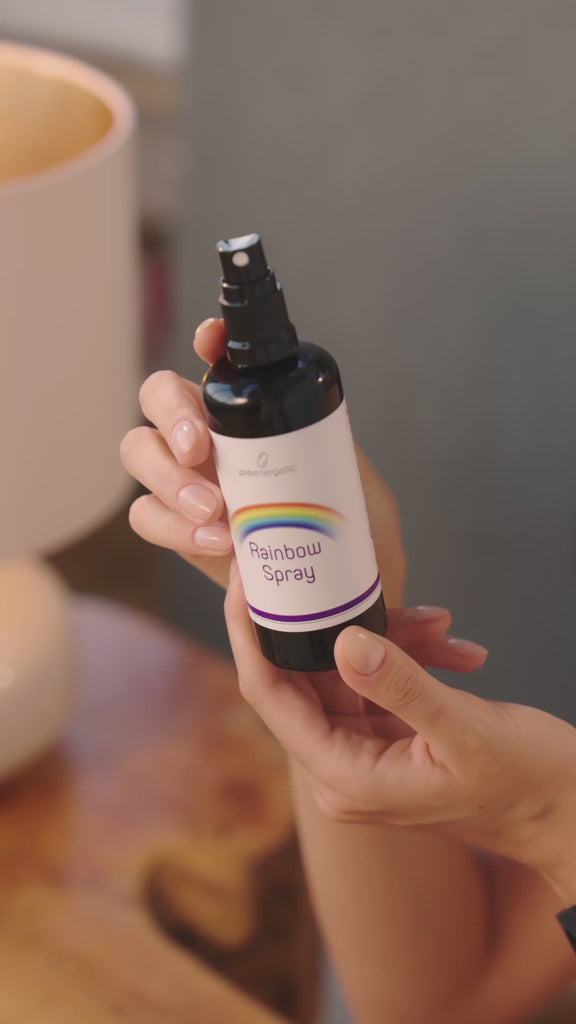 Person sitzt entspannt auf einem Sessel, hält das Rainbow Spray in der Hand und genießt den Moment in ruhiger Wohnumgebung