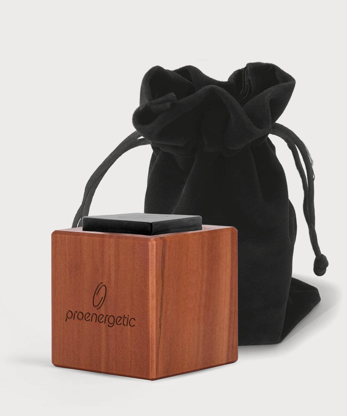 Holzwürfel mit ProEnergetic Logo und schwarzem Obsidian Stein vor schwarzem Stoffbeutel.