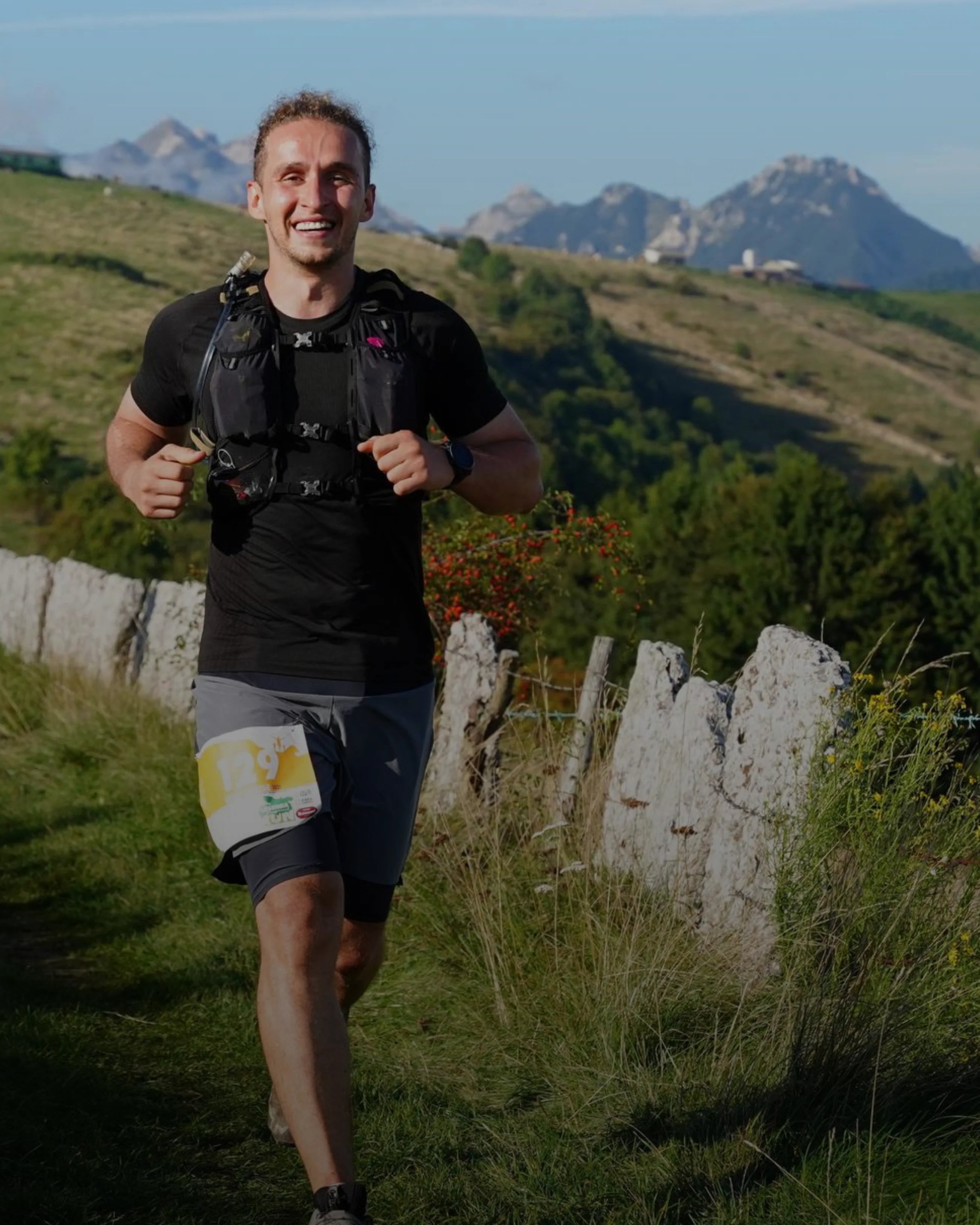 Mann läuft Ultramarathon auf Bergtrail in den Dolomiten mit felsigen Gipfeln im Hintergrund