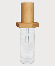 Vital Energizer von ProEnergetic. Holzaufsatz mit Metallstäben auf transparentem Glas mit eingraviertem ProEnergetic Logo.